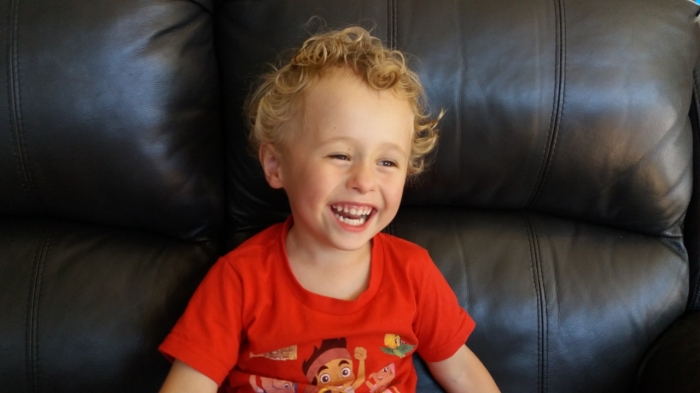 Happy toddler boy smiling on couch